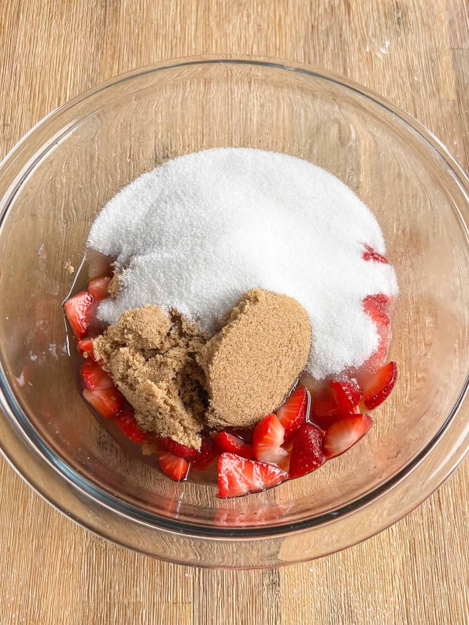 strawberries eggs and sugar in a glass bowl