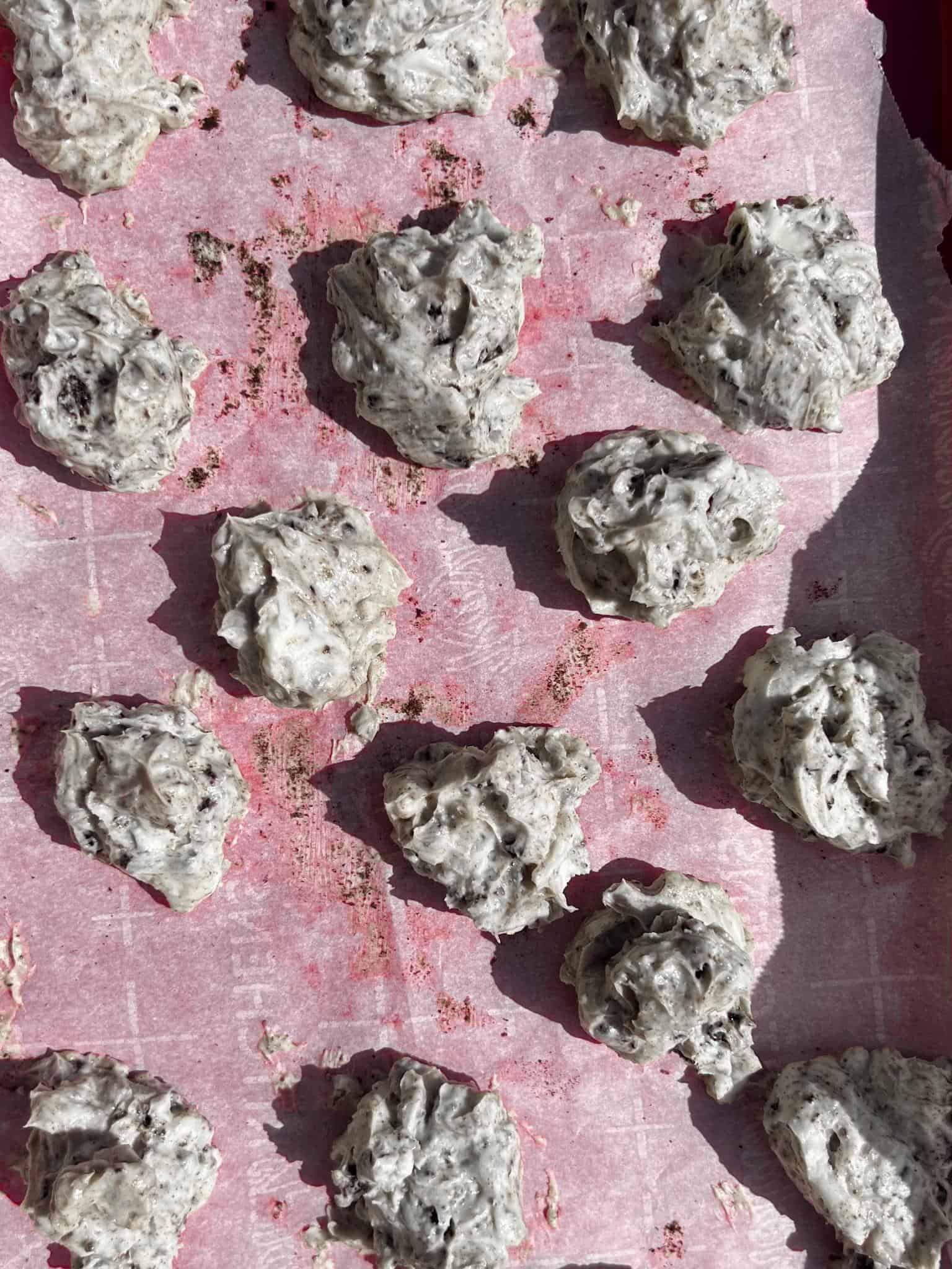 Oreo Cheesecake Cookies (Stuffed!) 4 Oreo cheesecake filling divided out into 16 spoonfuls sitting on a sheet tray about to be put in the freezer