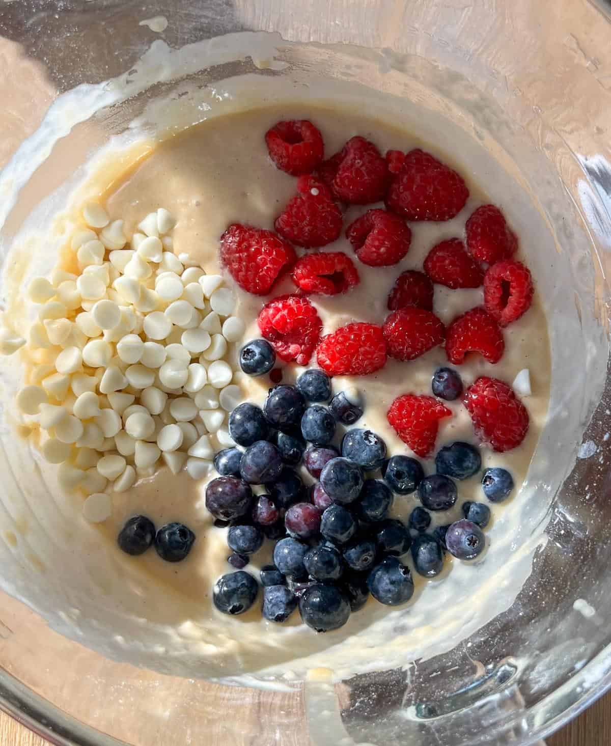 Raspberry Blueberry White Chocolate Muffins (red white and blue!) 8 Muffin batter in a glass bowl with the raspberries, blueberries, and white chocolate chips added but not yet mixed in