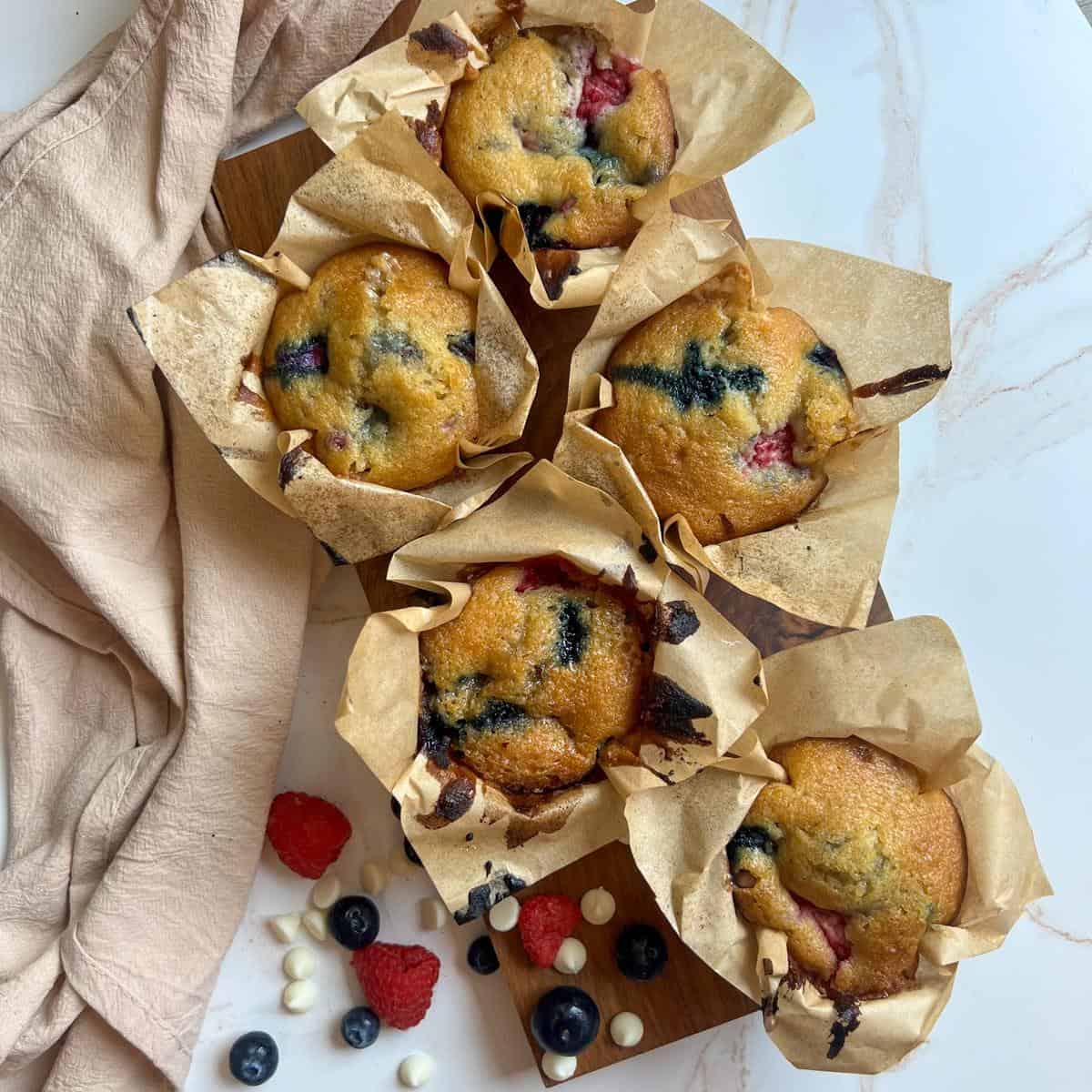 Raspberry Blueberry White Chocolate Muffins (red white and blue!) 7 Muffins in their liner laid out on a table