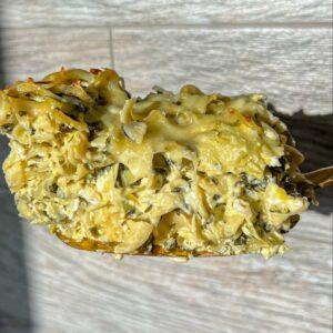 Spinach and Artichoke Noodle Kugel 10 close up of a slice of spinach and artichoke cheesy noodle kugel