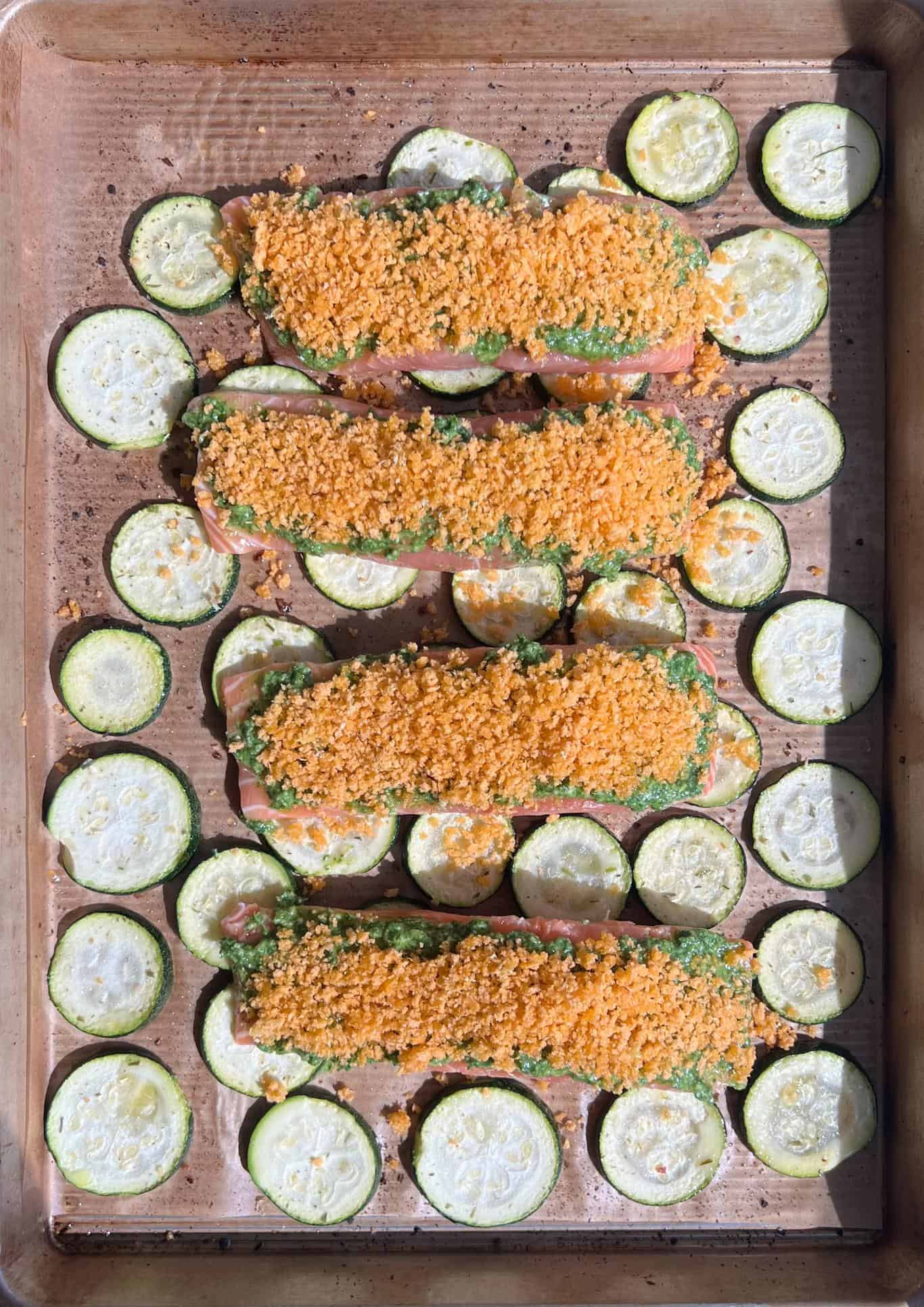uncooked salmon with the pesto and lemon crust over a bed of zucchini