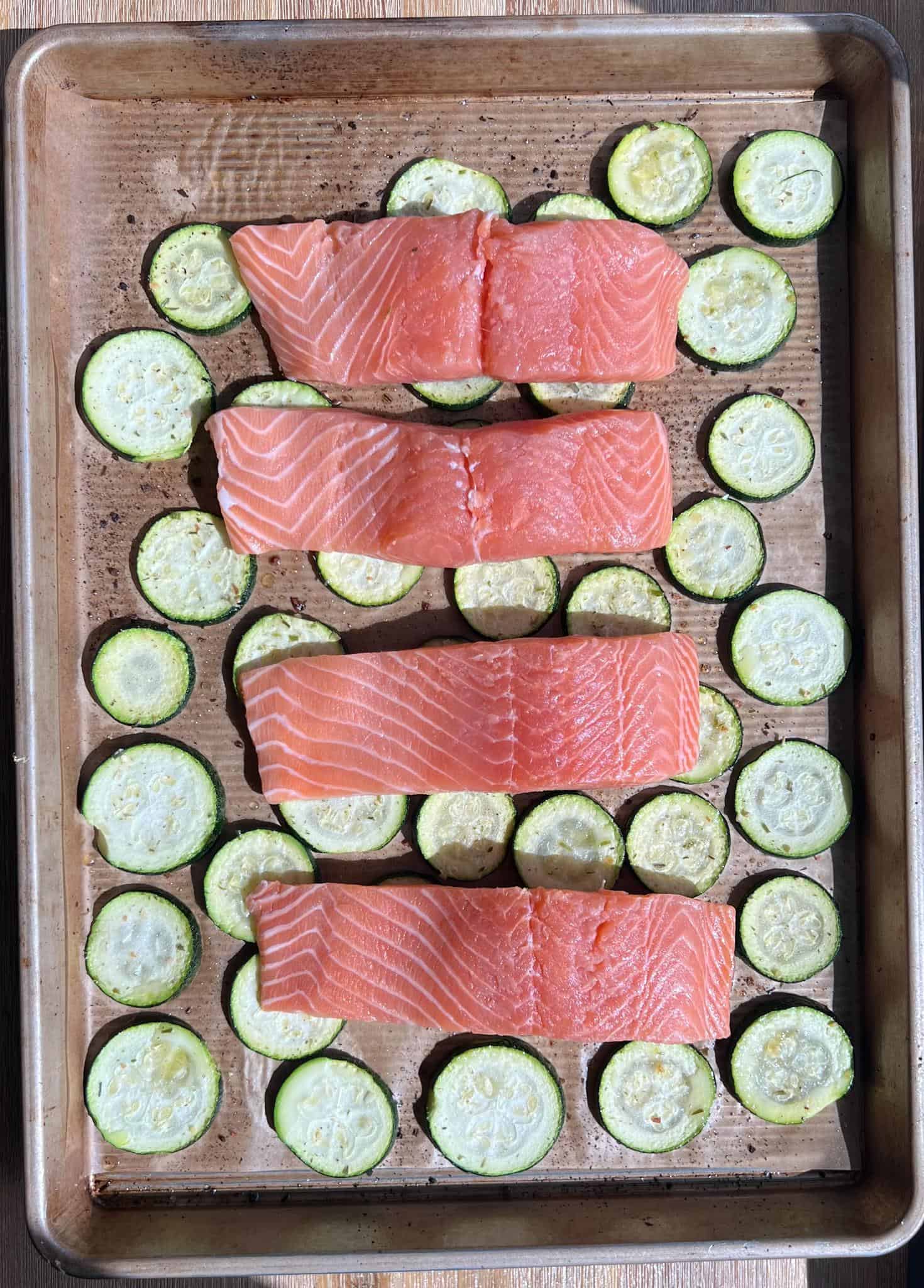 uncooked salmon over a bed of zucchini