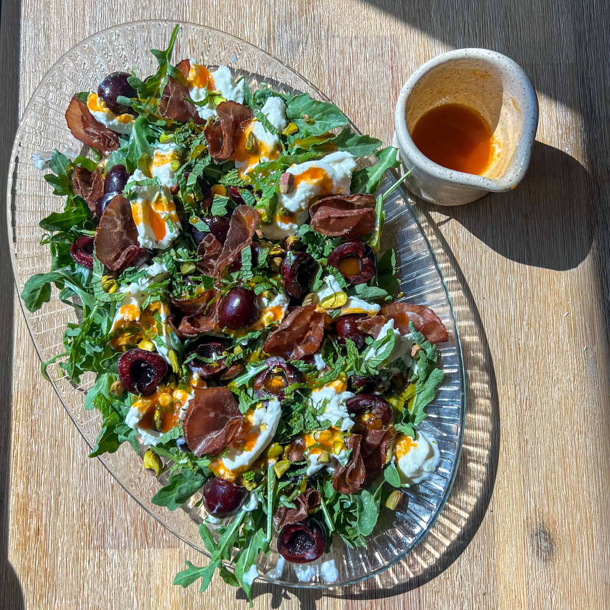 Summer Cherry and Burrata Salad 2 Summer cherry and burrata salad with hot honey dressing on the side