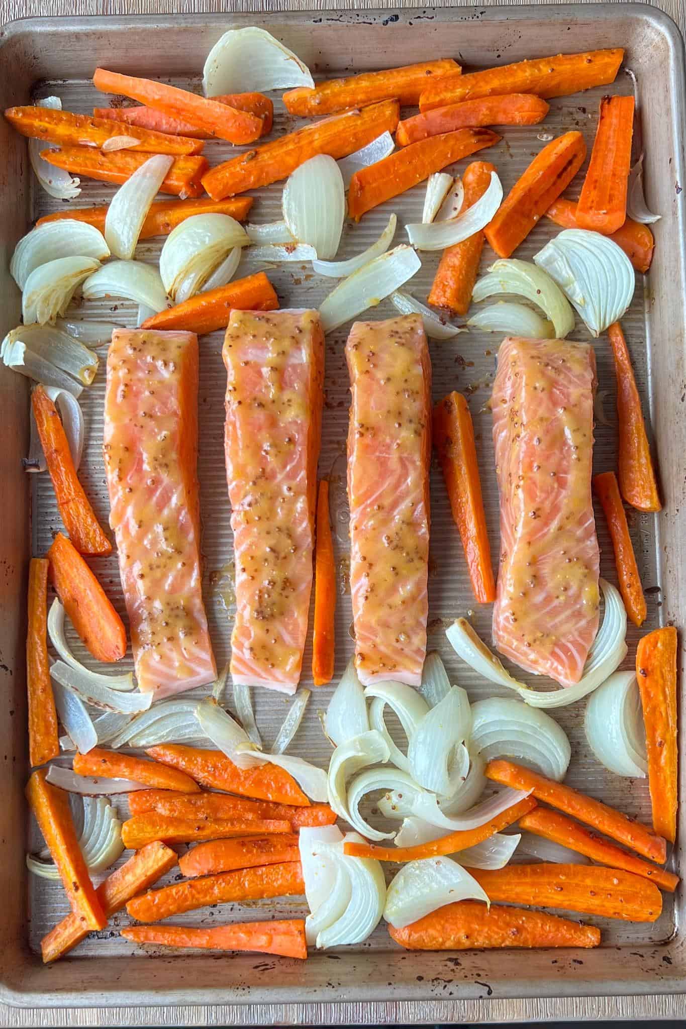 Honey Dijon Glazed Salmon 4 Honey dijon mustard glazed salmon on the sheet tray before the salmon being roasted, the veggies have already been par-baked