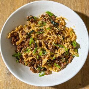 Korean Inspired spicy gochujang ground beef over a bed of noodles