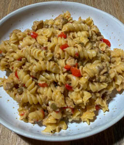 Plate of high fiber pasta with turkey taco meat, a lot of cheese, vegetables, and lentils or beans.