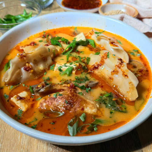 Red Curry Dumpling Soup 3 Bowl of red curry dumplings soup with tofu, mushrooms, spinach, and garnish