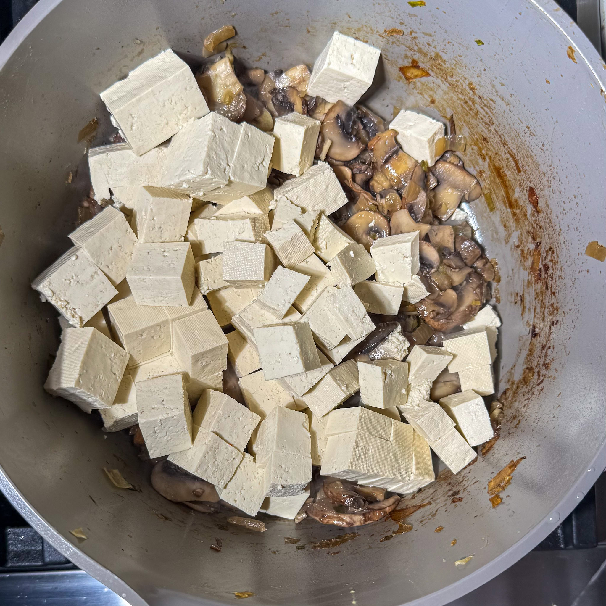 Added tofu to the pot of aromatics and mushrooms