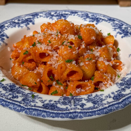 Plate of healthy pasta alla vodka topped with parmesan and parsley