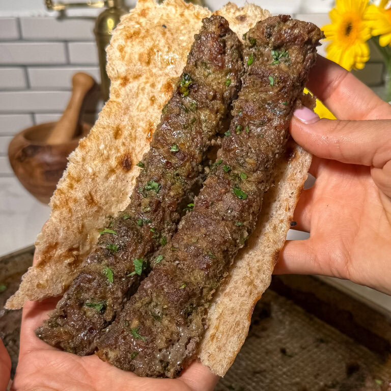 two pieces of baked sheet pan koobideh kabob in bread