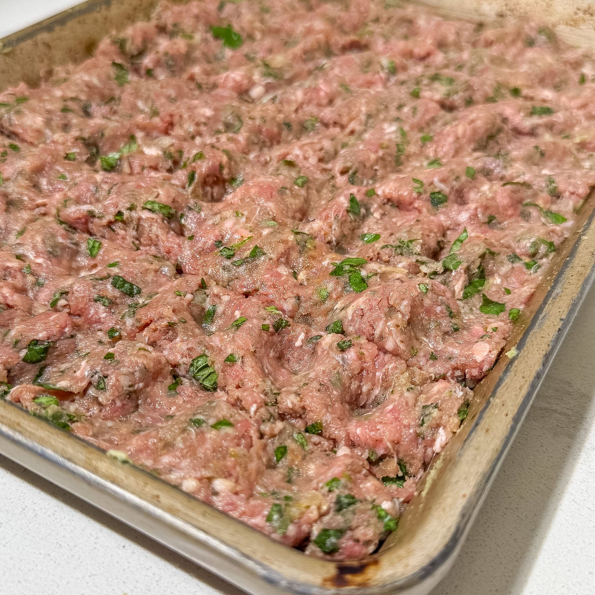 close up unbaked sheet pan koobideh kabob